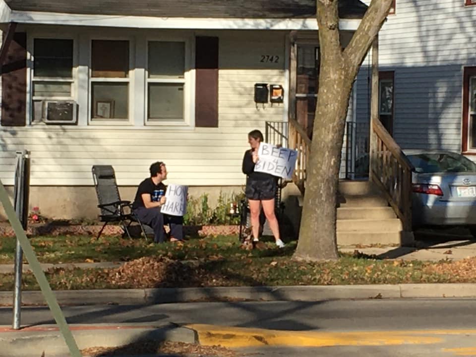 Neighbors holding signs Honk for Harris, Beep for Biden